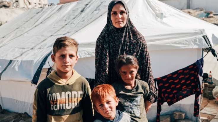 Palestinian mother with children in tent after Israeli strike in Gaza